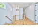 Bright hallway featuring hardwood floors, modern lighting, and wood railing at 631 Linfield Dr, Durham, NC 27701