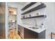 Hallway with modern sink and wine cooler below, shelves, and closet in the background at 631 Linfield Dr, Durham, NC 27701