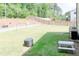 Spacious backyard featuring a lush lawn, established border fence, and outdoor cooking & dining area at 642 The Parks Dr, Pittsboro, NC 27312