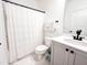 Functional bathroom with a shower curtain, toilet, vanity with a single sink, and simple, modern finishes at 642 The Parks Dr, Pittsboro, NC 27312