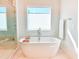 Serene bathroom showcasing a freestanding tub beneath a window with privacy blinds, complemented by marble flooring at 642 The Parks Dr, Pittsboro, NC 27312