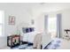 Bright bedroom featuring a white bed with blue accent pillows, light walls, and ample natural light from large windows at 642 The Parks Dr, Pittsboro, NC 27312