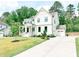 Stunning white two-story home with a manicured lawn and a long concrete driveway at 642 The Parks Dr, Pittsboro, NC 27312