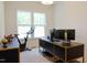 Bright home office with large windows, modern desk, and exercise equipment, perfect for productivity and fitness at 642 The Parks Dr, Pittsboro, NC 27312
