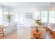 Bright open-concept living space with a dining area, cozy sofa, and views of the outdoors through large windows at 642 The Parks Dr, Pittsboro, NC 27312