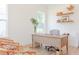 Bright office space featuring wood desk, wicker chairs, floating shelves, and natural light from two windows at 642 The Parks Dr, Pittsboro, NC 27312