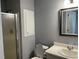 Bathroom with a shower, toilet, and a single sink with framed mirror above it at 703 W Church St, Angier, NC 27501