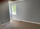 Simple bedroom features neutral walls, a window offering sunlight, and cozy carpet flooring at 703 W Church St, Angier, NC 27501
