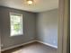 A cozy bedroom with gray walls, a window letting in natural light, and neutral-colored carpeting at 703 W Church St, Angier, NC 27501