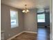 Bright dining room features hardwood flooring, a modern chandelier, and large windows at 703 W Church St, Angier, NC 27501