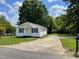 Quaint single-story house featuring white siding, blue shutters, and a long driveway at 703 W Church St, Angier, NC 27501