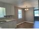 Kitchen features white cabinets, laminate countertop, gray walls and hardwood floors at 703 W Church St, Angier, NC 27501