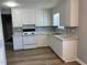 Well-lit kitchen featuring white cabinets, laminate countertops, and new appliances at 703 W Church St, Angier, NC 27501