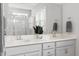 Bathroom with a double vanity, neutral gray paint, modern faucets and fixtures, and a large mirror at 706 Great Ridge Pkwy, Chapel Hill, NC 27516