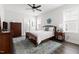 Bright bedroom featuring a ceiling fan, comfortable bed with dresser, and natural light at 706 Great Ridge Pkwy, Chapel Hill, NC 27516