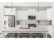 Bright kitchen featuring white cabinets, stainless steel appliances, and large island with barstool seating at 706 Great Ridge Pkwy, Chapel Hill, NC 27516