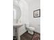 Powder room with a pedestal sink, framed art, wood look flooring, and a decorative rug at 706 Great Ridge Pkwy, Chapel Hill, NC 27516