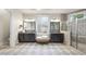 The primary bath offers double vanities, tiled floors, an ottoman, and a glass enclosed shower at 7312 Hasentree Way, Wake Forest, NC 27587