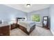 Bright blue bedroom with a platform bed, a side table with a lamp, and a full-length mirror at 7312 Hasentree Way, Wake Forest, NC 27587