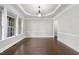 This dining room features hardwood floors, a tray ceiling, and a window with lots of natural light at 7312 Hasentree Way, Wake Forest, NC 27587
