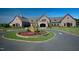Stone clubhouse with manicured landscaping and a circular driveway offers a grand entrance at 7312 Hasentree Way, Wake Forest, NC 27587