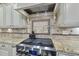 This is a kitchen featuring stainless steel stove top with a tile backsplash and granite countertops at 7312 Hasentree Way, Wake Forest, NC 27587