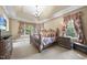 The main bedroom features a trey ceiling, carpet, a decorative bed frame and windows with nice views at 7312 Hasentree Way, Wake Forest, NC 27587