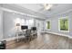 Well-lit home office with desk, ceiling fan, and multiple windows overlooking the lawn at 7312 Hasentree Way, Wake Forest, NC 27587
