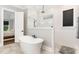Modern bathroom with a freestanding tub, glass-enclosed shower, and neutral tile at 8017 Discovery Falls Trl, Wake Forest, NC 27587