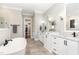 Elegant bathroom featuring dual sinks, granite countertops, a walk-in closet, and a soaking tub at 8017 Discovery Falls Trl, Wake Forest, NC 27587