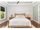 Spacious bedroom boasts tray ceilings, paneled walls, and hardwood floors at 8017 Discovery Falls Trl, Wake Forest, NC 27587