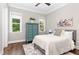 Comfortable bedroom with large windows, hardwood floors, and a decorative blue dresser at 8017 Discovery Falls Trl, Wake Forest, NC 27587