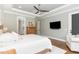 Spacious bedroom with hardwood floors, a ceiling fan, and a wall-mounted television at 8017 Discovery Falls Trl, Wake Forest, NC 27587