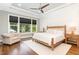 Bright, spacious bedroom boasts tray ceilings, large windows, and hardwood floors at 8017 Discovery Falls Trl, Wake Forest, NC 27587