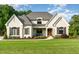 Charming two-story white brick home featuring manicured landscaping and a welcoming front porch at 8017 Discovery Falls Trl, Wake Forest, NC 27587