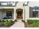 Inviting front porch with seating area, featuring a wood door and manicured landscaping at 8017 Discovery Falls Trl, Wake Forest, NC 27587