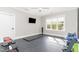 Home gym with equipment, mounted TV, large window and rubber floor at 8017 Discovery Falls Trl, Wake Forest, NC 27587