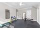 Home gym includes rubber floor, wall mirror, exercise bench, and workout accessories at 8017 Discovery Falls Trl, Wake Forest, NC 27587