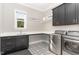 Functional laundry room with modern washer/dryer, counter space, and stylish tile floor at 8017 Discovery Falls Trl, Wake Forest, NC 27587