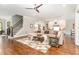 An inviting living room featuring hardwood floors, a cozy seating area, and an adjacent staircase at 8017 Discovery Falls Trl, Wake Forest, NC 27587