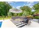 Relaxing outdoor patio features comfortable seating beneath a large umbrella, perfect for entertaining in style at 8017 Discovery Falls Trl, Wake Forest, NC 27587