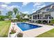 Backyard pool with patio featuring a lounge area, screened porch, and lush landscaping for an outdoor oasis at 8017 Discovery Falls Trl, Wake Forest, NC 27587