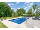 Inviting backyard pool is surrounded by lush greenery and a comfortable seating area for ultimate relaxation at 8017 Discovery Falls Trl, Wake Forest, NC 27587