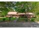 Charming brick home featuring a beautiful red roof, a welcoming porch, and mature trees in the front yard at 9108 Ransdell Rd, Raleigh, NC 27603