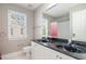 Bathroom featuring double sinks, a large mirror, and a window with a shower/tub combo at 9251 Palm Bay Cir, Raleigh, NC 27617