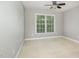 A bright bedroom featuring a large window, carpet, and ceiling fan, offering natural light at 9251 Palm Bay Cir, Raleigh, NC 27617
