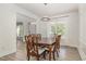 Bright dining room with wood floors, a chandelier, and a window with white curtains for natural light at 9251 Palm Bay Cir, Raleigh, NC 27617