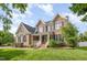 Charming two-story brick home with a well-manicured lawn and inviting front porch with white railing at 9251 Palm Bay Cir, Raleigh, NC 27617