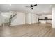 Open concept living area with wood floors, fireplace, staircase, and access to a white kitchen at 9251 Palm Bay Cir, Raleigh, NC 27617