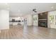 Open floor plan with wood floors, a fireplace, white cabinetry, and a view of the modern kitchen at 9251 Palm Bay Cir, Raleigh, NC 27617